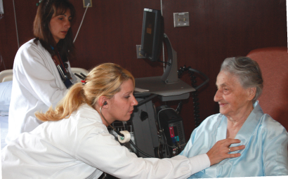 Doctor listening to an elderly woman's heart beat