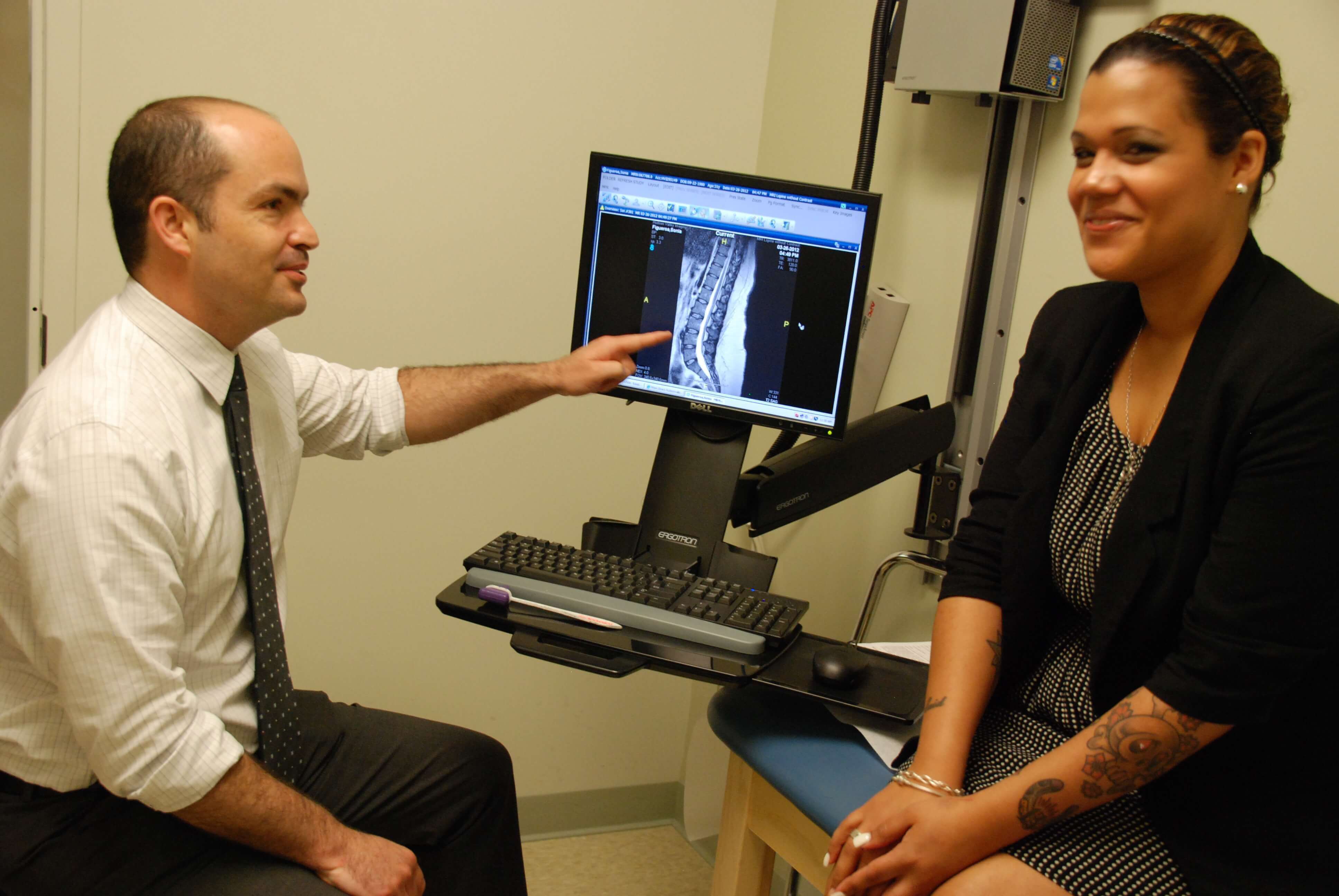 Doctor with patient looking at scan of spine