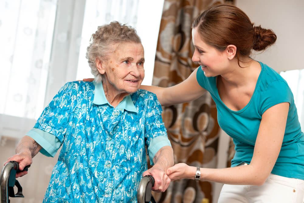 Nurse helping an elderly woman walk