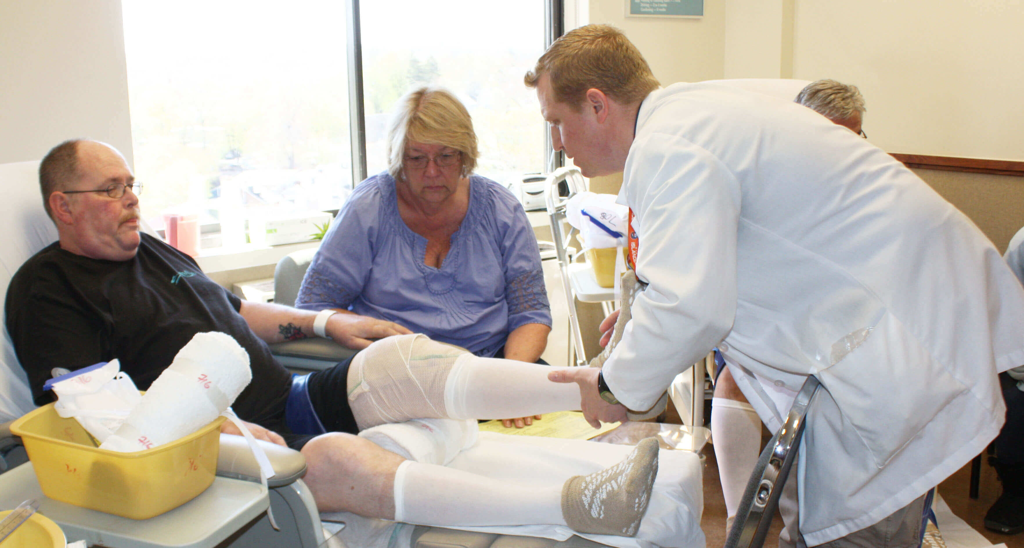 Doctor and Nurse massaging a wounded man's legs