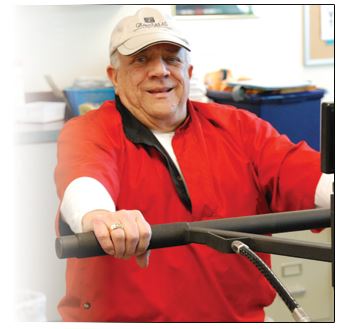 smiling elderly man pushing a machine